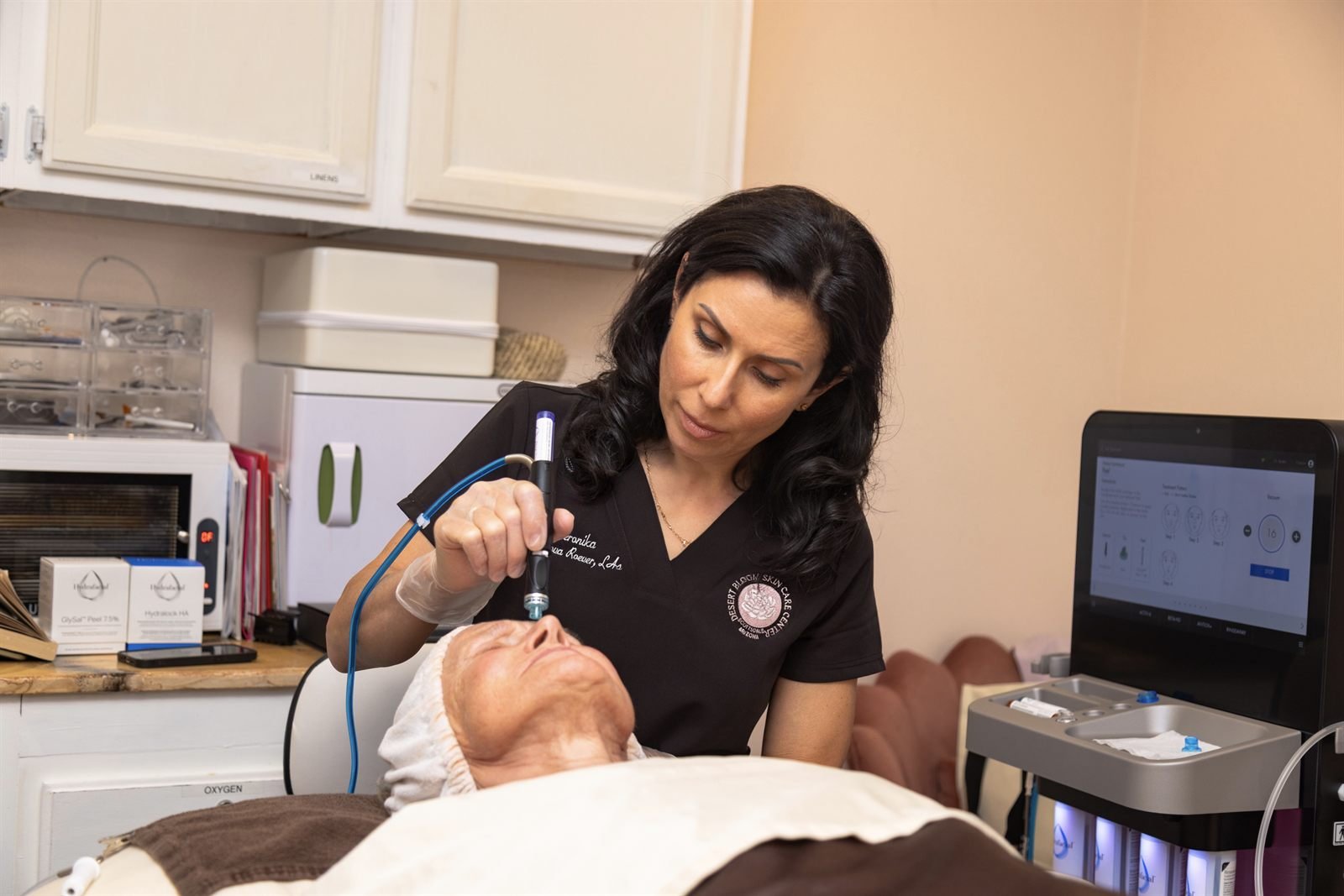 Aesthetician Veronika Morozova giving a HydraFacial Syndeo treatment at Desert Bloom Skin Care